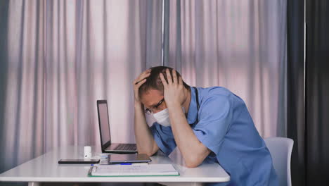 frustrated doctor in facial mask looks at tablet in office