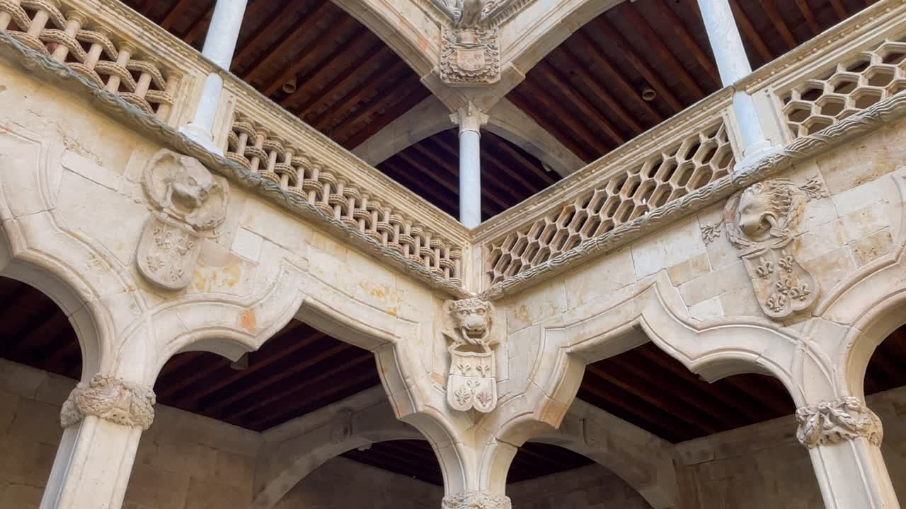 We see one of the corners of the patio of the Casa de las Conchas, there are wooden ceilings and that majestic stone balustrade, shields with animal heads appear, some decorative and others heraldic.
