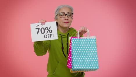 abuela mayor mostrando bolsas de compras y hasta un 70 por ciento de descuento en inscripciones pancarta, viernes negro