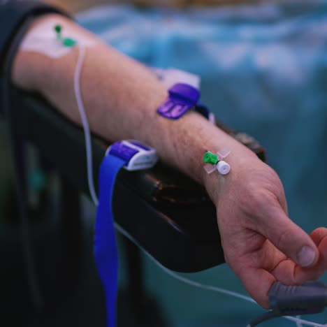 man's hand during surgery. anesthetized patient hand with heart rate monitor and dropper catheter in operating room. close-up