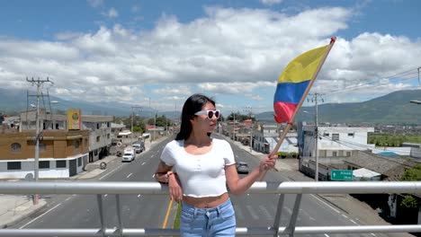 agitando la bandera de ecuador sobre la autopista vacía, sudamérica mujer patriótica