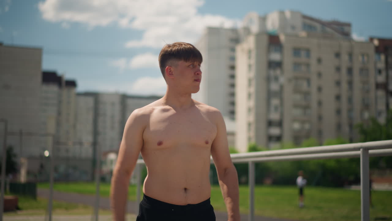 햇빛을 받으며 활기 넘치는 발레 동작, 도시 옥상에서 넓은 제스처를 연습하는 즐거운 젊은 예술가, 야외에서 팔을 크게 움직이며 감정을 표현하는 생동감 넘치는 개인