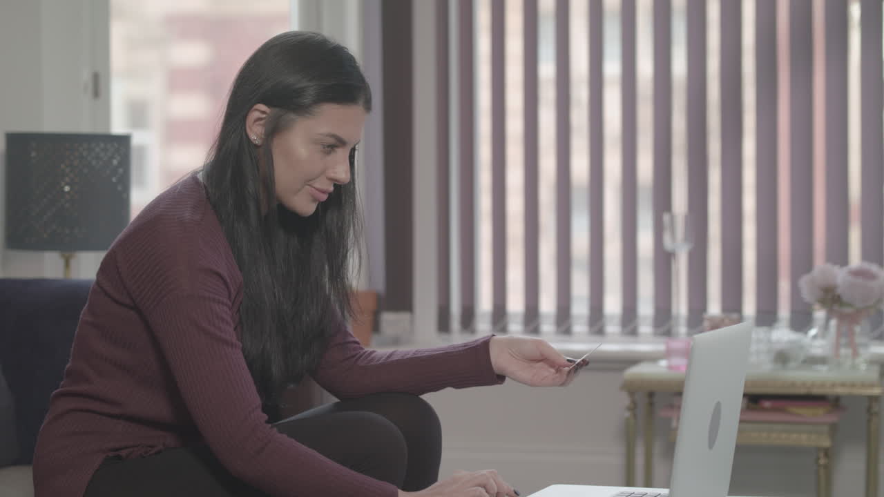 joven atractiva que usa una computadora portátil para hacer una compra en línea