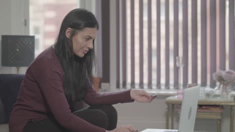 joven atractiva que usa una computadora portátil para hacer una compra en línea