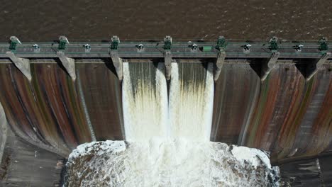 rising up and looking down aerial footage of water being released from lauriston reservoir, in central victoria. october 2022.