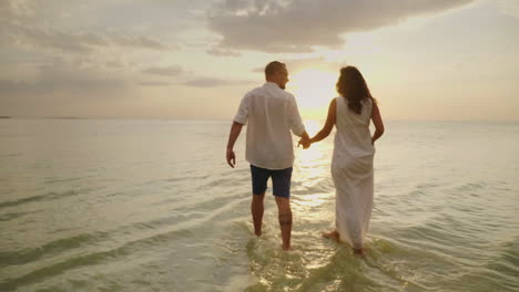 young couple in love in light clothes carefree running on a clean tropical beach