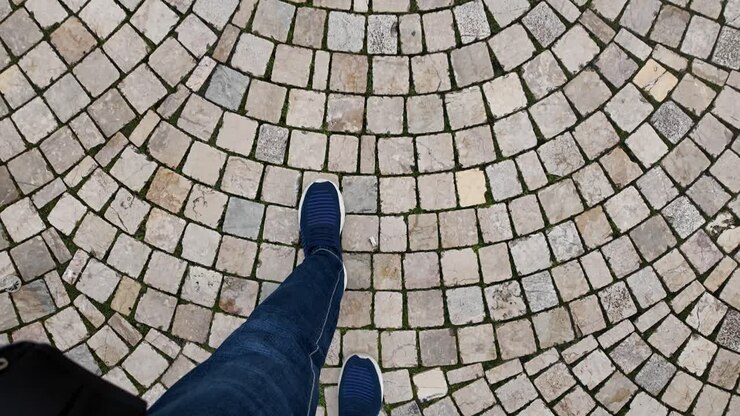 Person walking on a patterned cobblestone path
