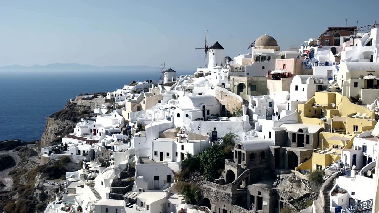 fotografía diurna de casas y molinos de viento en oia, santorini