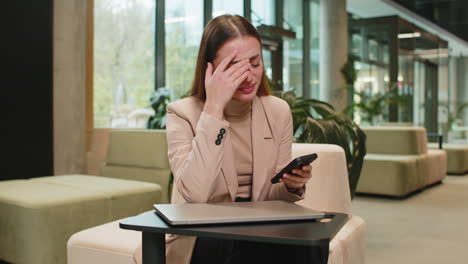 Caucasian business woman use smartphone surprised by bad news fortune loss fail lottery results