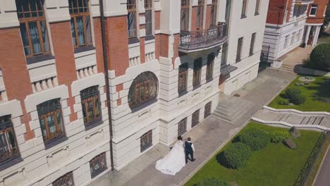 woman with groom walks along beautiful building upper view