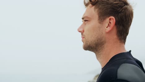 side view of male surfer standing on the beach 4k