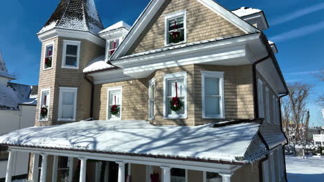 beautiful victorian home with christmas wreath decoration in winter snow