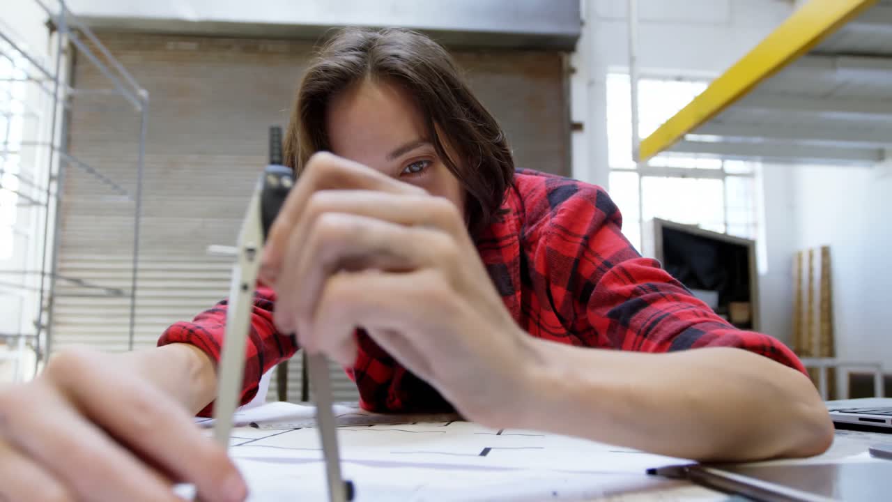 soldadora trabajando en el escritorio en el taller 4k