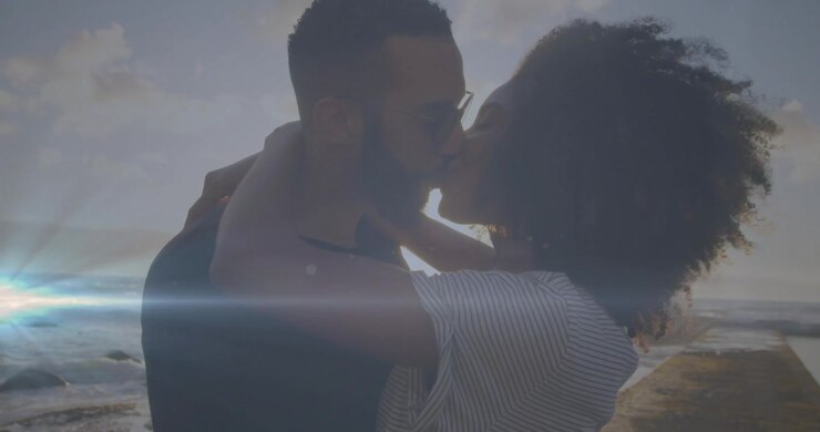 Femme se jetant dans les bras d'un homme sur une jetée, créant un reflet d'objectif qui anime la silhouette pour une scène de vie.