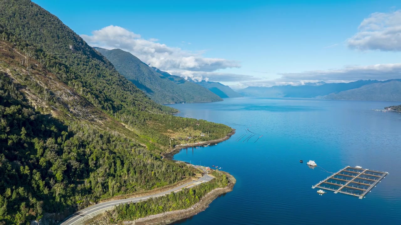 Il fiordo di Hornopiren si estende all'orizzonte in questo splendido hyperlapse aereo. Antiche foreste, una tortuosa strada costiera e allevamenti di salmoni rivelano la natura selvaggia della Patagonia cilena