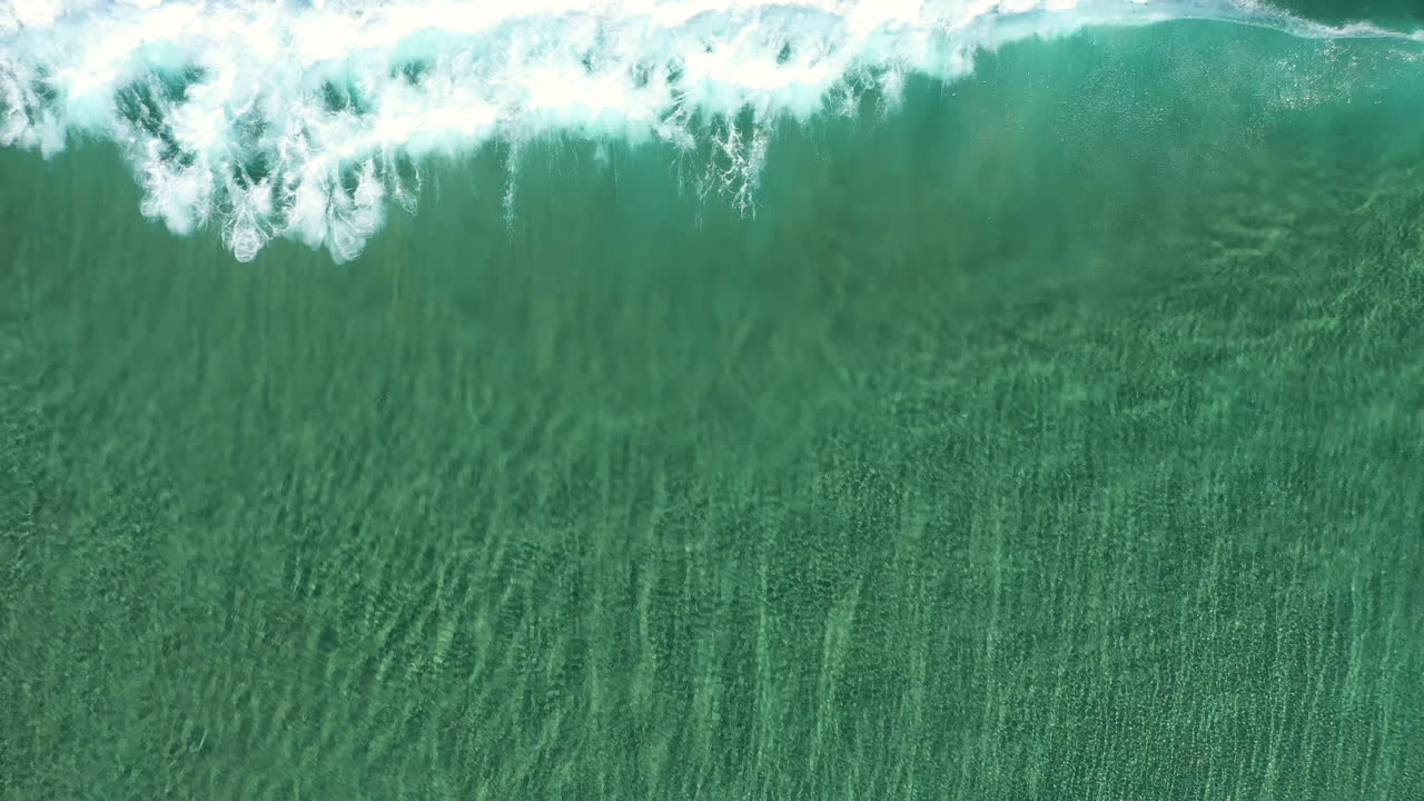 vista superior de 4k toma de drones de mar turquesa cristalino y rompimiento de olas