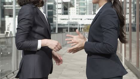 una foto recortada de mujeres de negocios estrechando la mano.