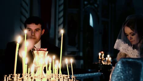 recién casados en la iglesia frente al candelabro