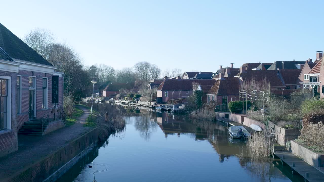 Pittoresco canale di un villaggio olandese con case tradizionali e riflessi