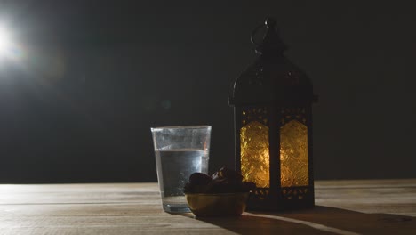 stationary shot of lantern water and dates on table for ramadan