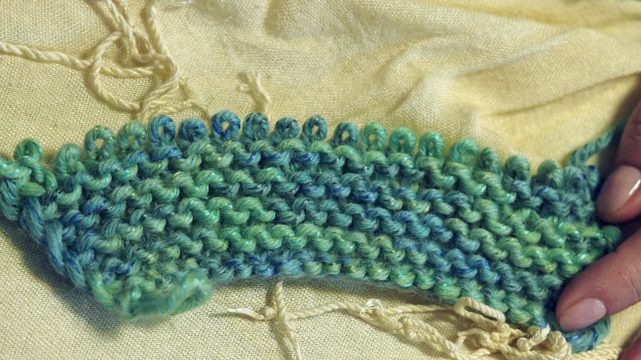 손가락은 따뜻한 전기 조명 아래에서 뜨개질을 니다.