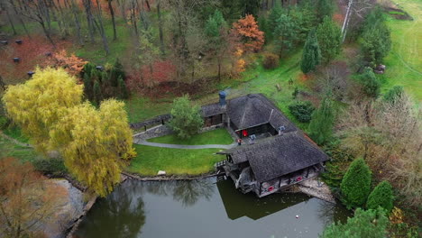 Rest of tourists in autumn forest. Resting building with pond in beautiful forest area