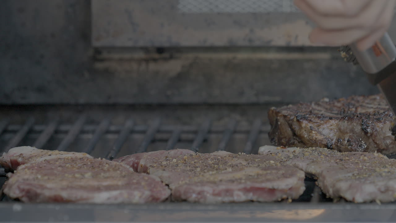 외부의 뜨거운 그릴에 놓인 스테이크의 근접 촬영