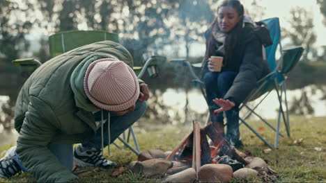 Fire, camping and couple in a forest relax