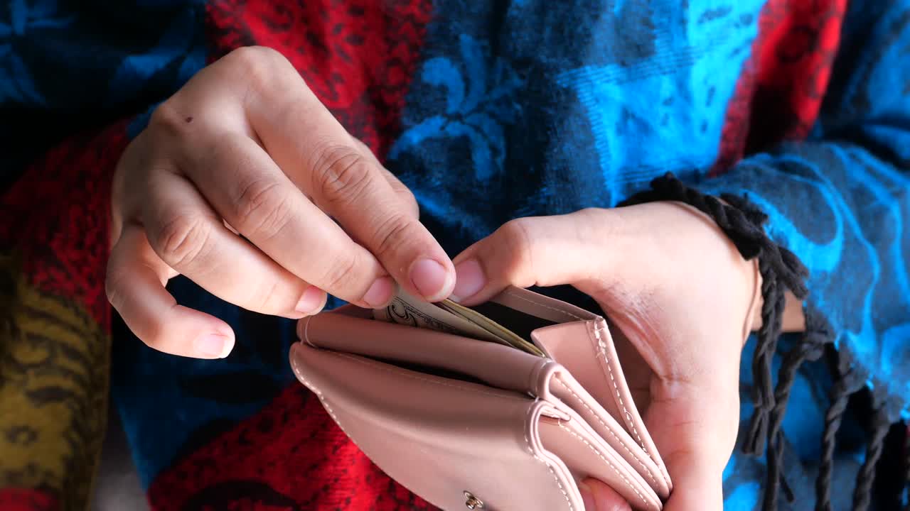 Vrouw controleert haar portemonnee: leeg of vol?