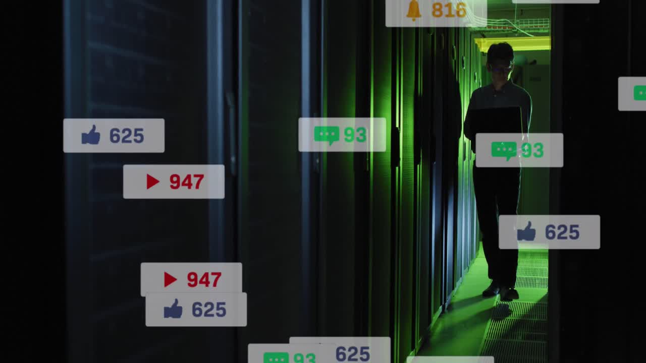 анимация икон социальных сетей над азиатским инженером-мужчиной, использующим ноутбук в комнате компьютерного сервера