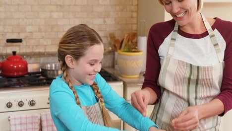 hija sonriente amasando la masa mientras la madre está de pie junto a ella 4k 4k