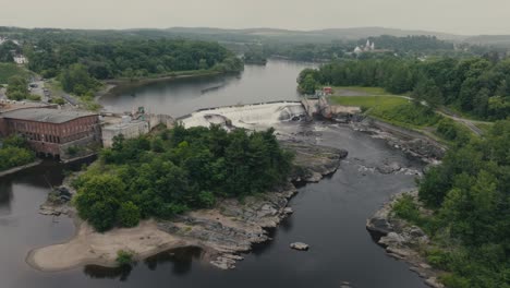 dam on the river with water flowing rapid, sherbrooke, canada - aerial drone shot