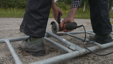 Man-at-home-grinding-metal-pipe