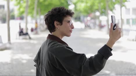 Smiling-woman-taking-selfie-with-smartphone-outdoor