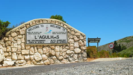 vista de bajo ángulo del letrero de bienvenida a la aldea costera del cabo agulhas, overberg