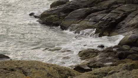 meereswellen schlagen gegen felsen im küstendorf mui ne, vietnam