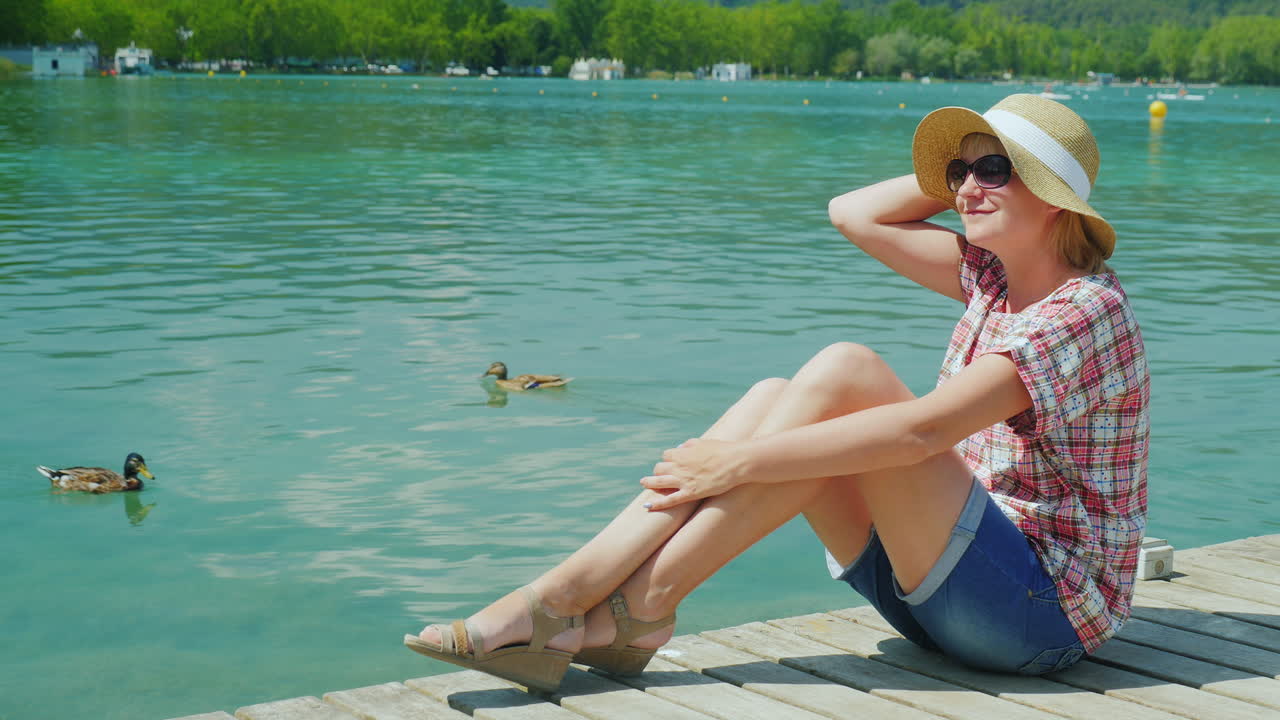 오리가 스페인에서 수영하는 호수에서 휴가를 즐기는 여성 관광객