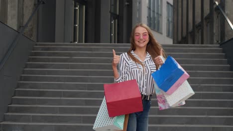 Girl-raising-shopping-bags,-looking-satisfied-with-purchase,-enjoying-discounts-on-Black-Friday
