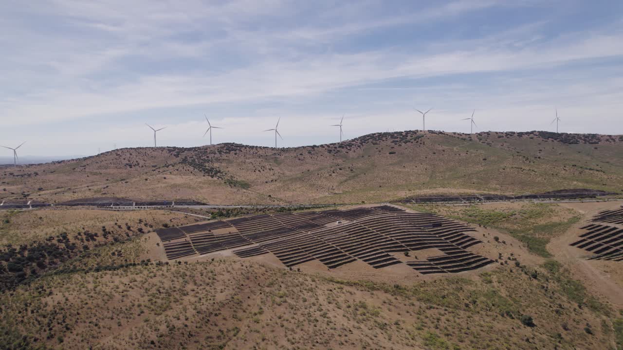 vista aérea en órbita de plasencia, españa occidental, panel solar en el campo de caceres y turbinas eólicas en el paisaje montañoso