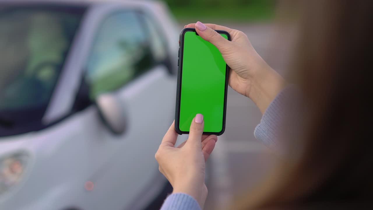 chica con pantalla verde móvil toma fotos en el estacionamiento. accidente automovilístico espejo roto