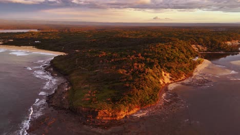 drone medium orbit of sussex inlet beach at dusk with gentle waves and golden hues along shoreline