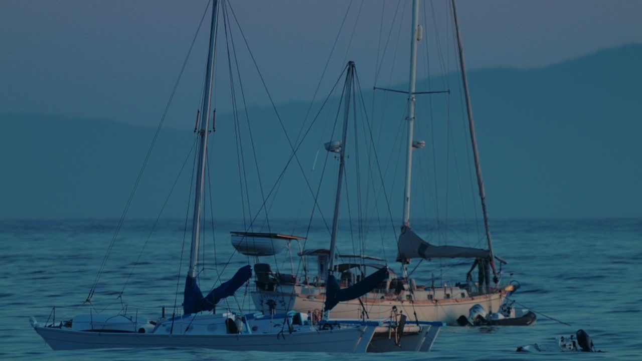 Slow Motion Shot of Sailboats Floating Calmly off Santa Barbara Coast During Twilight