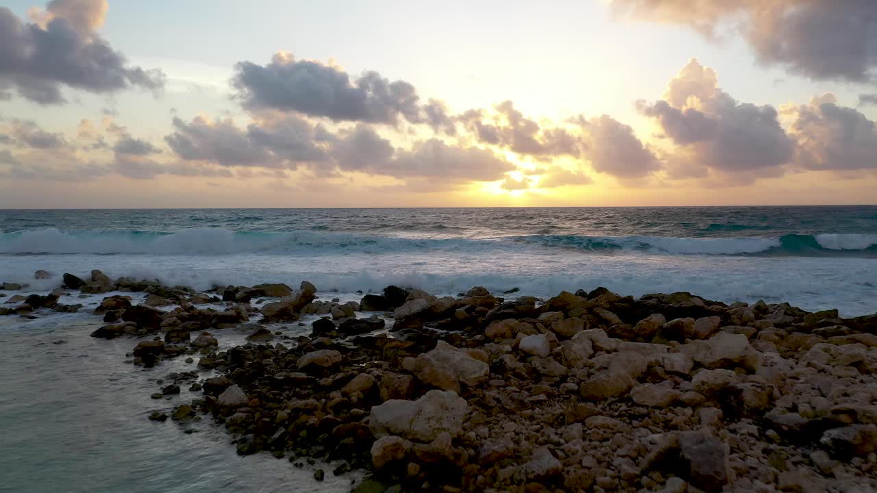 vista al atardecer desde un dron mientras las olas chocan en una playa tropical en tulum, méxico