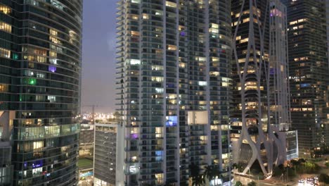 imagen reveladora del horizonte del centro de miami edificios de oficinas y apartamentos al atardecer iluminados con luz, cámara lenta aérea