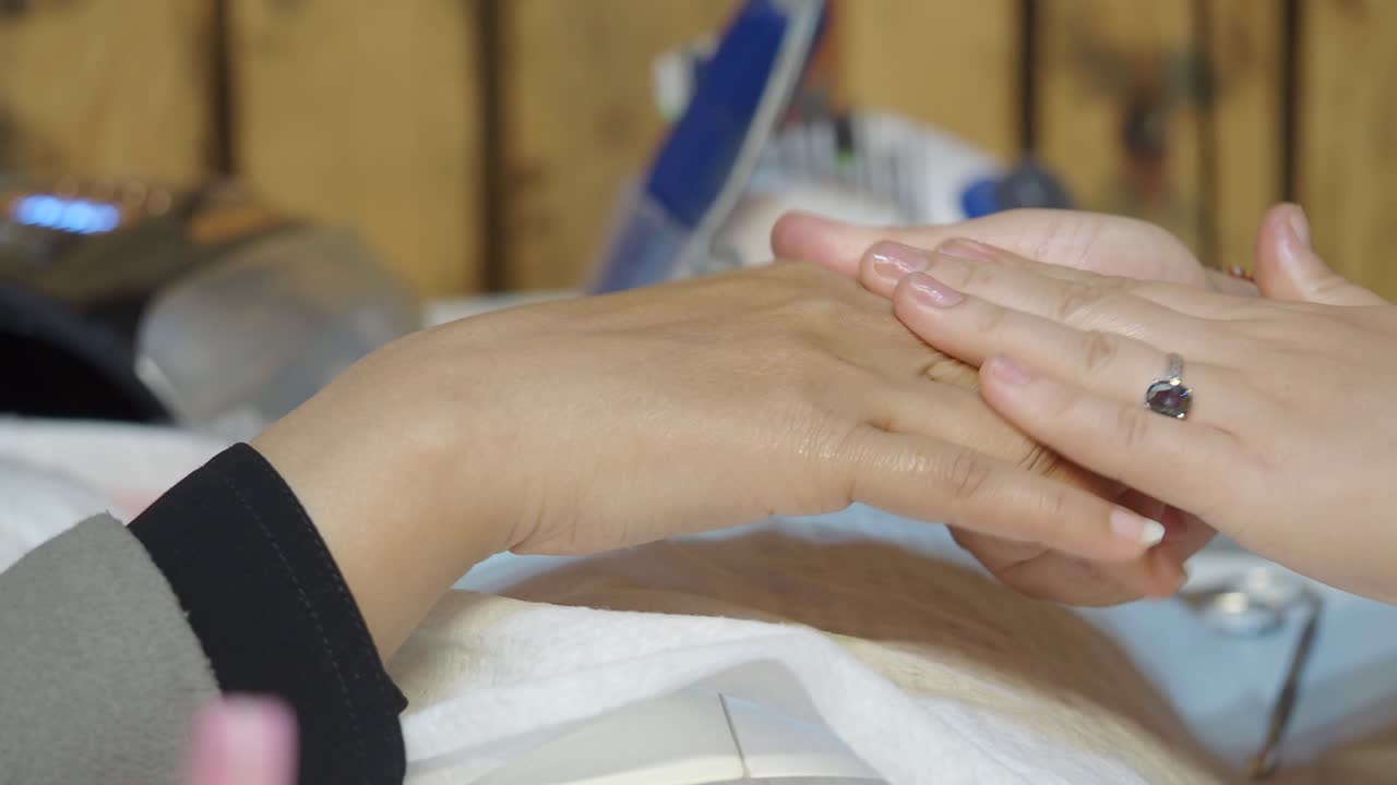 Beautician Applying Oil and Massaging Client's Hands