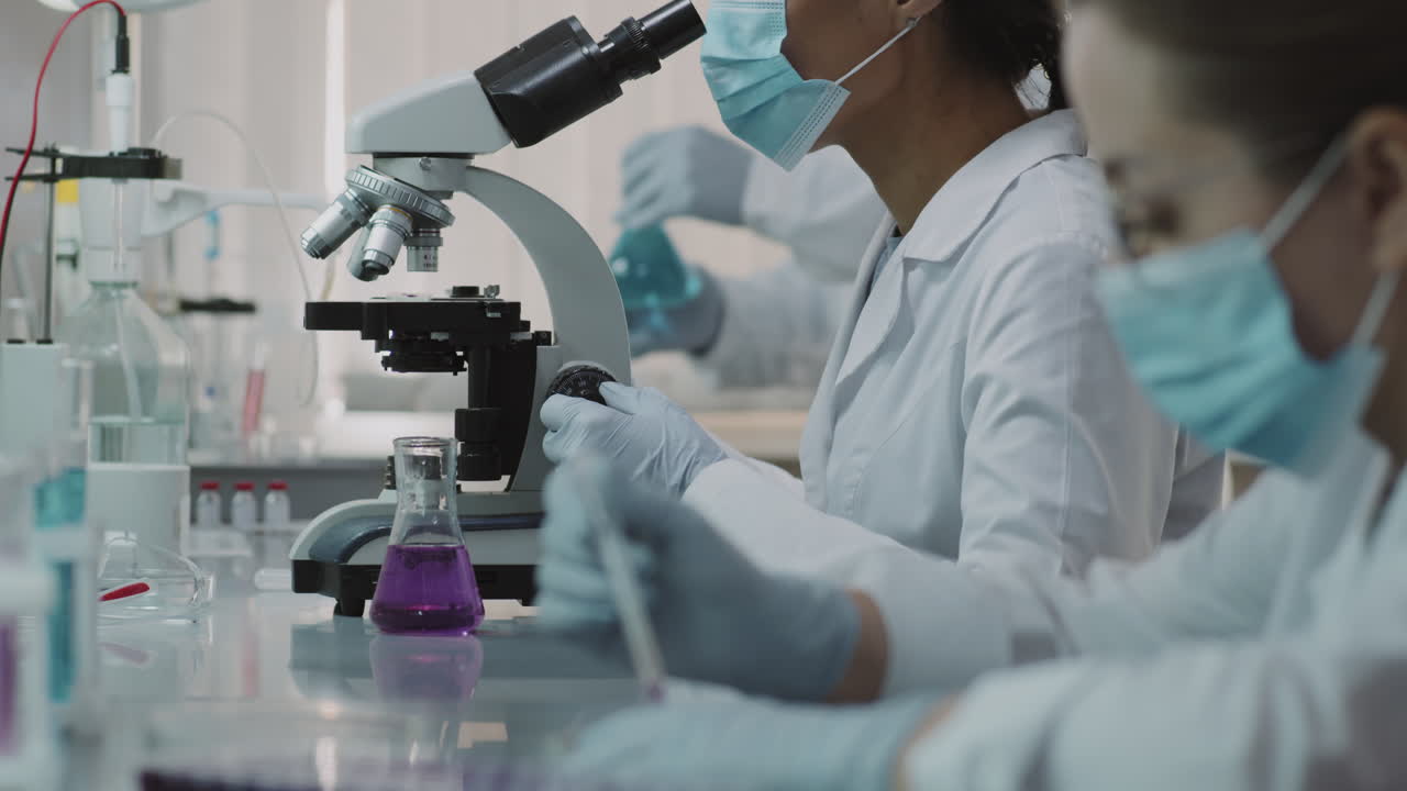 Scientists in Face Masks Doing Research in Lab