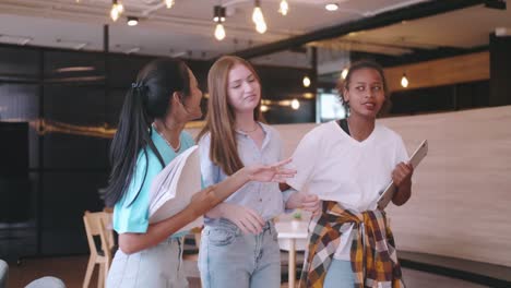 multiethnic students having fun chatting in school talking and laughing together.