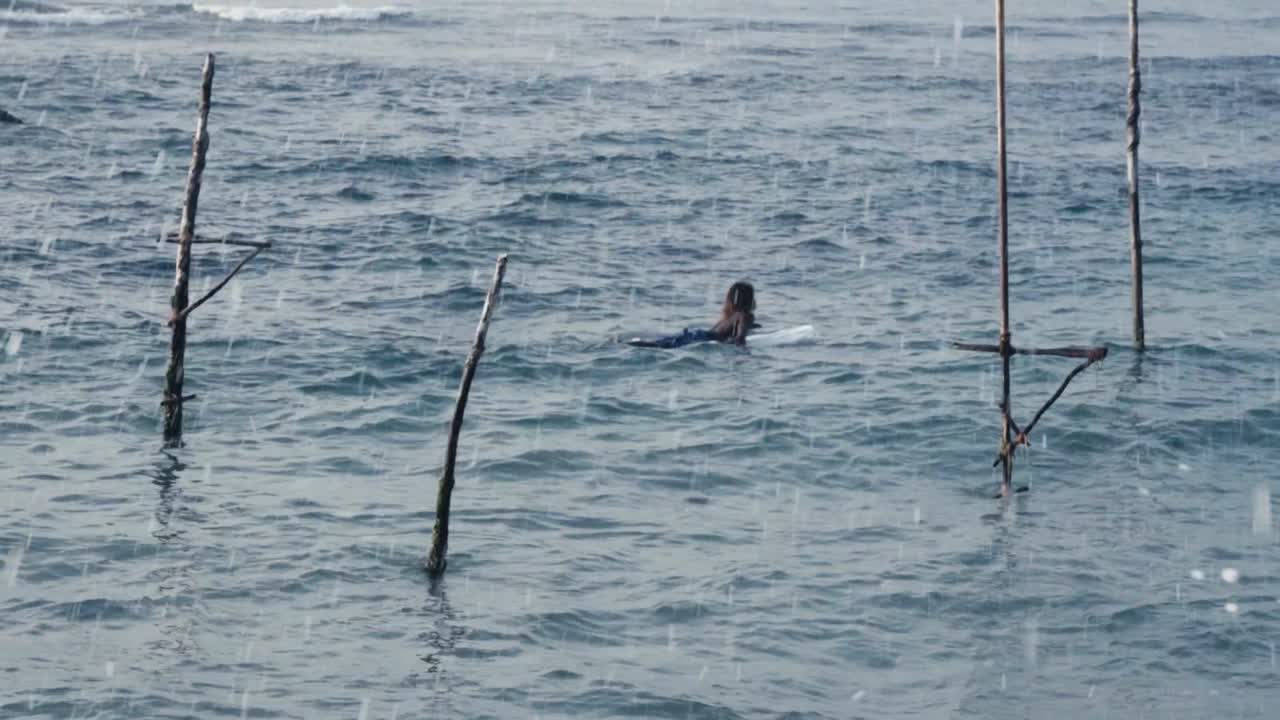 스리랑카 웰리가마 의 파도 있는 바다 를 가로지르는 서핑 보드 에 누워 있는 여자 - 중간  ⁇