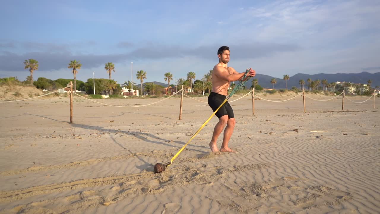 atleta muscular entrenamiento ejercicios funcionales realiza arrastre en la playa con peso