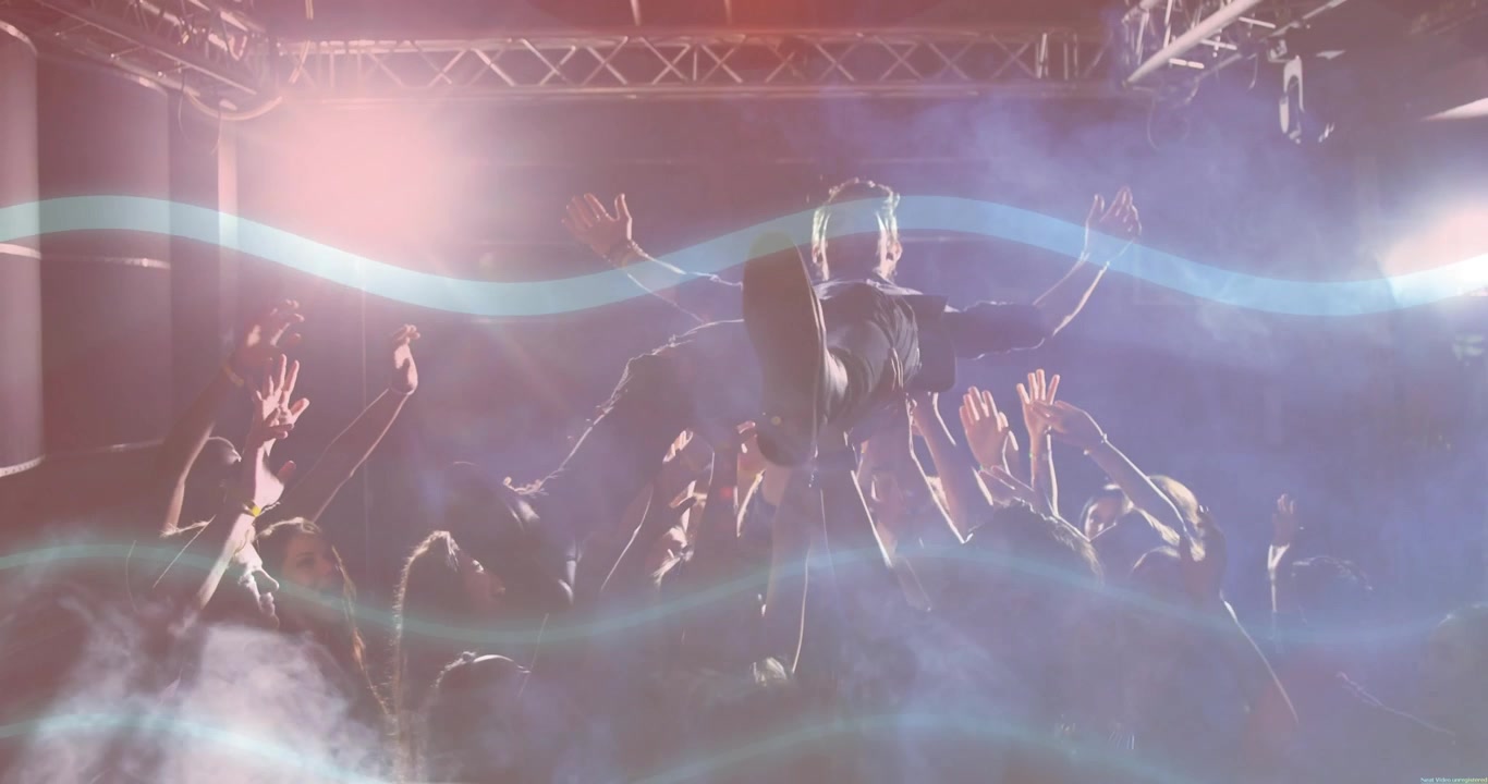 Artiste masculin en concert avançant, exhortant le public, provoquant la foule le soulevant au-dessus de la structure et du brouillard.